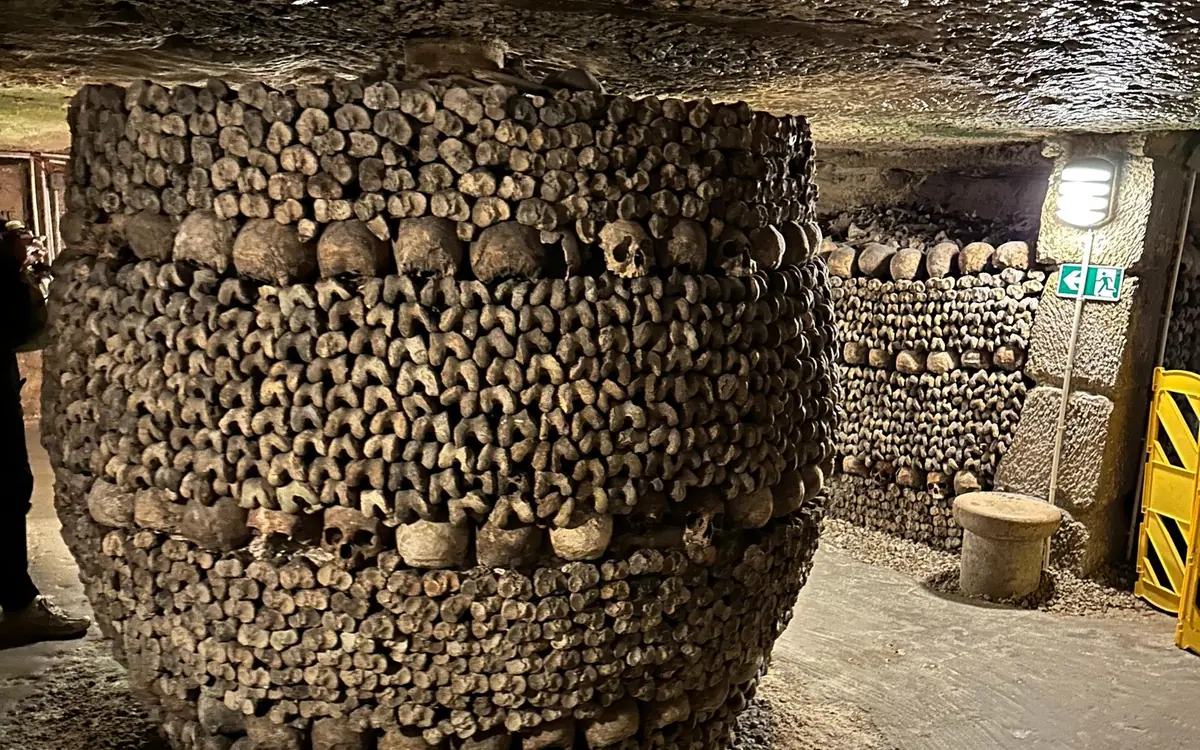 A pillar of stacked skulls and bones inside the ossuary