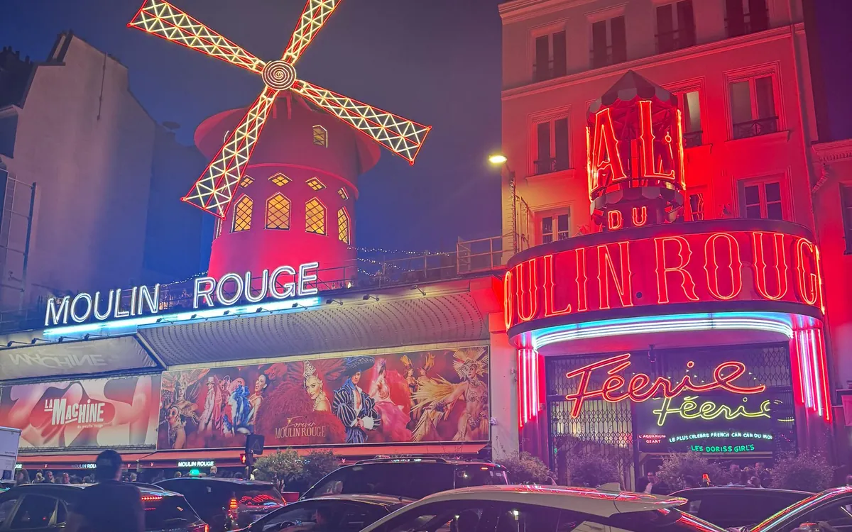 The red windmill and neon sign of the Moulin Rouge at night