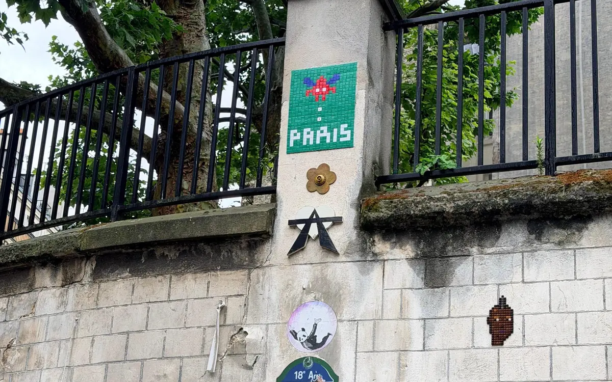 Mosaic street art on a stone wall in the 18th arrondissement, the district of Montmartre