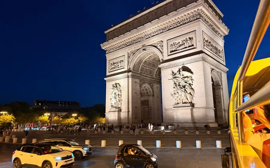 The Eiffel Tower lit at night with searchlight beams