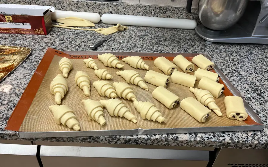 Croissants shaped and laid out on a baking tray before the oven