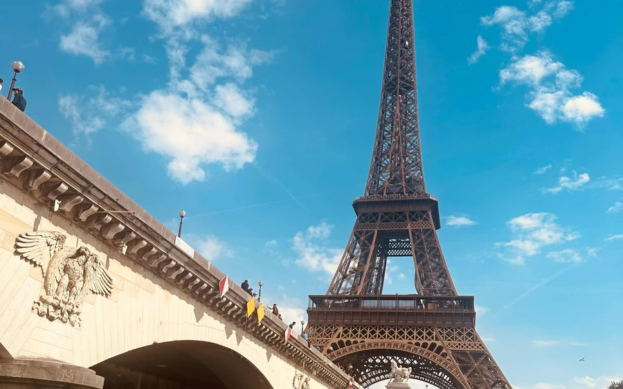 The Eiffel Tower seen through a bridge arch from the river