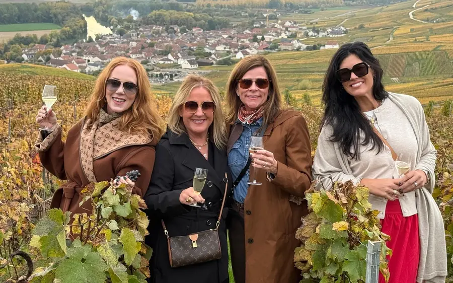 Four women with glasses of Champagne among the vines
