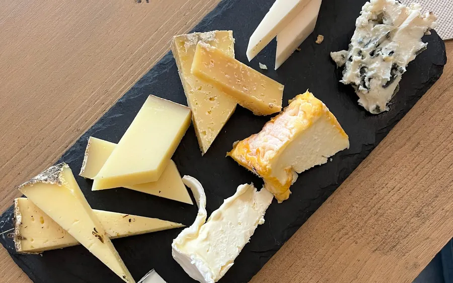 A slate board of French cheeses cut for tasting