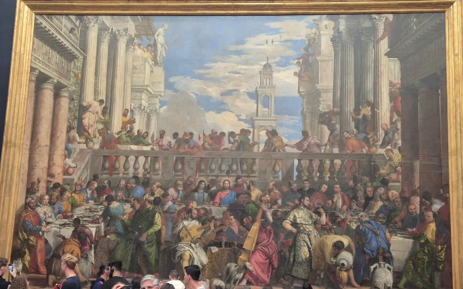 A vast Renaissance banquet painting in a gilded frame at the Louvre