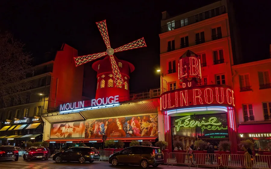 The red windmill and neon sign of the Moulin Rouge at night