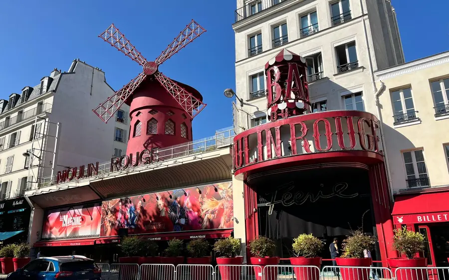 The red facade and windmill of the Moulin Rouge by day