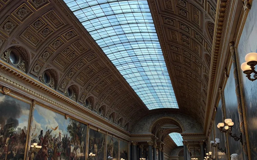 A long gallery of paintings under a glass roof at Versailles