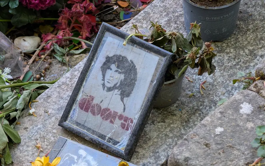 Flowers and a small framed portrait left on a grave at Père Lachaise