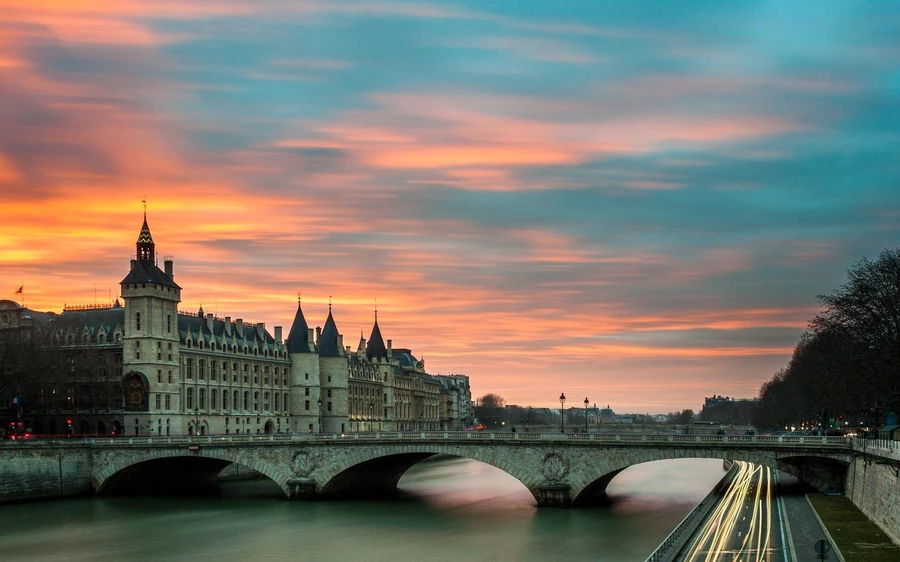 The Conciergerie and a bridge over the Seine at sunset